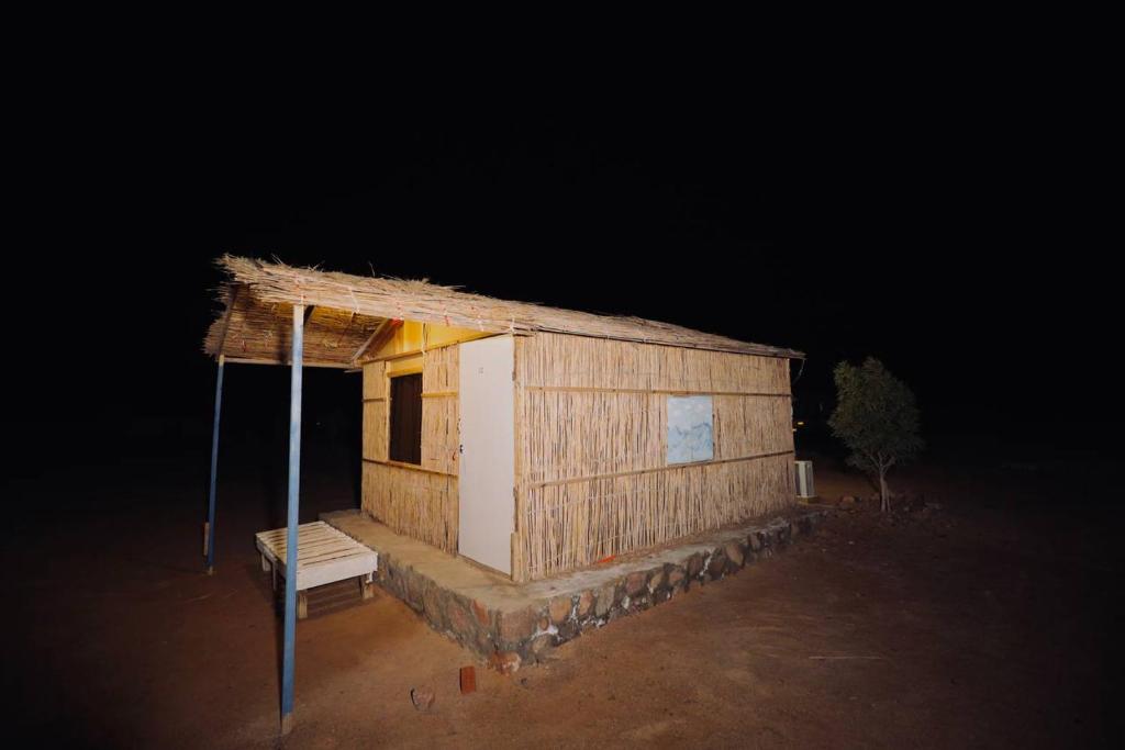 a small building with a roof at night at New Droub Camp in Nuweiba