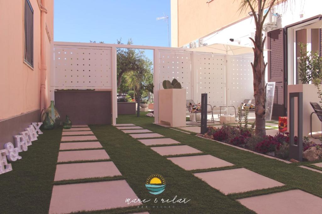 Un jardín con un camino de piedra con un cono de helado. en Mare & Relax delux, en Margherita di Savoia