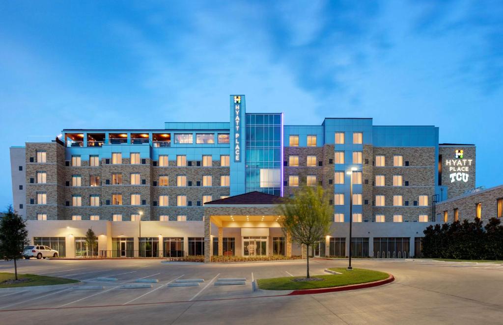 un grand bâtiment avec un parking en face de celui-ci dans l'établissement Hyatt Place Fort Worth/TCU, à Fort Worth