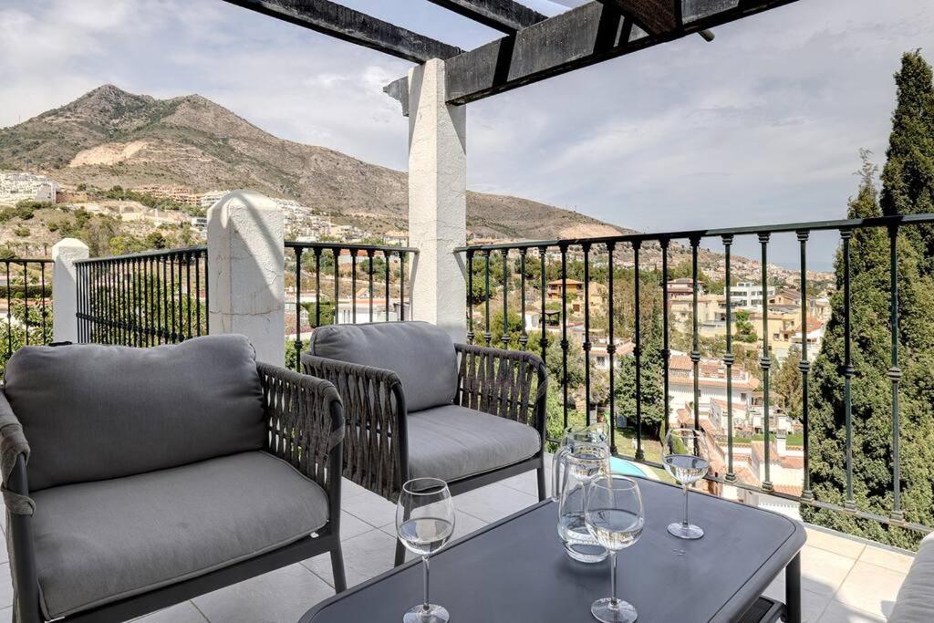a patio with two chairs and a table with wine glasses at 3 Bedroom Semi Detached Villa with Stunning Views! in Benalmádena