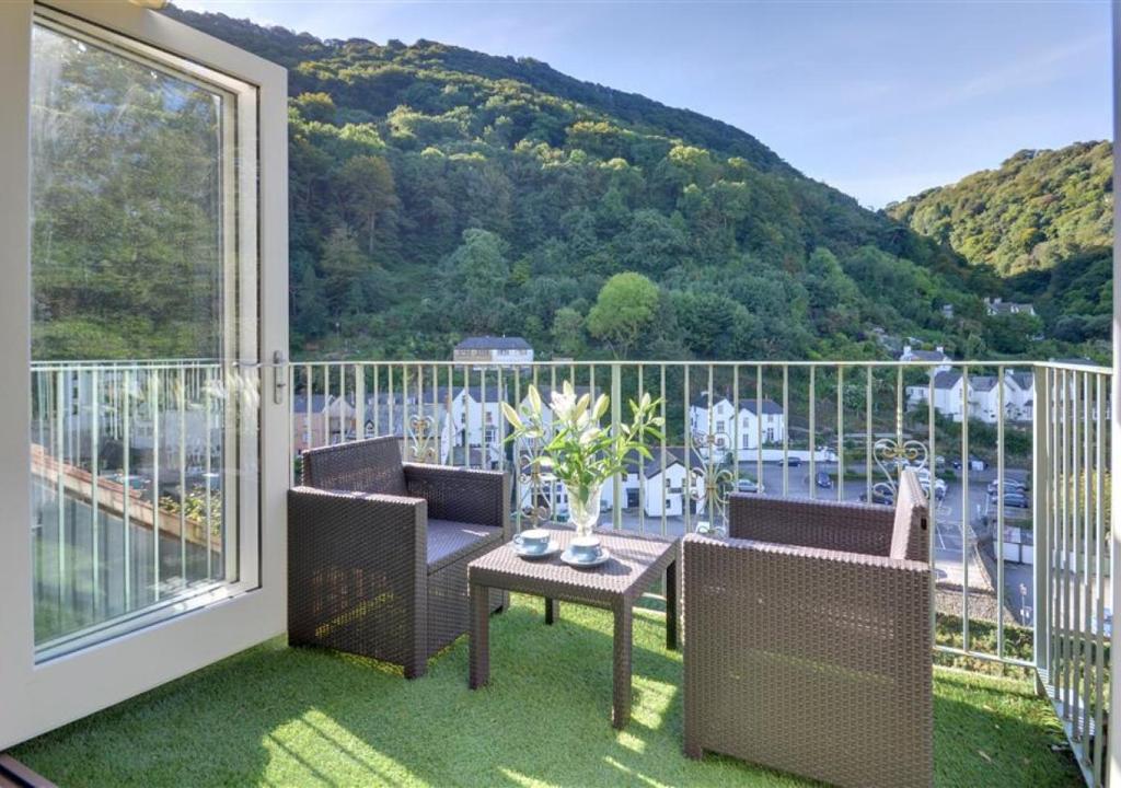 Un balcón con dos sillas y una mesa con vista. en Aberlyn, en Lynmouth