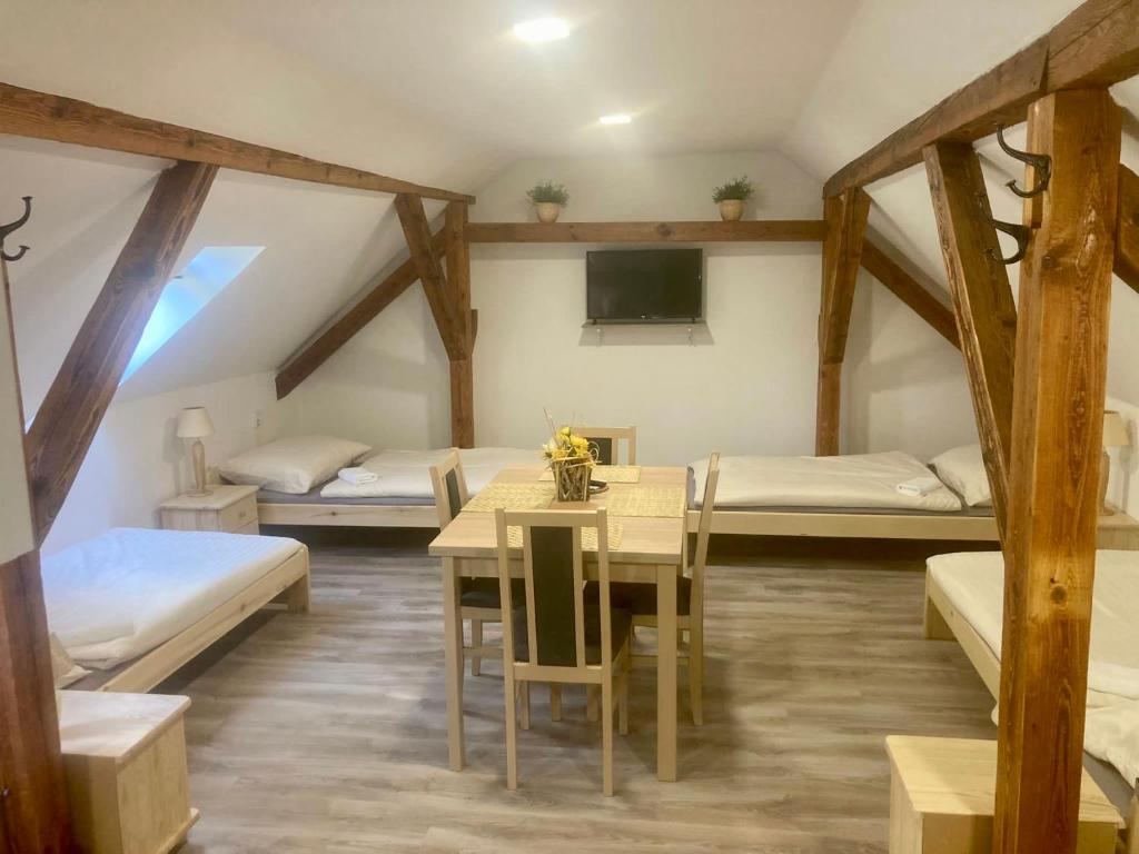 a room with two beds and a table and chairs at Apartmán Pod Zámkem in Moravský Krumlov