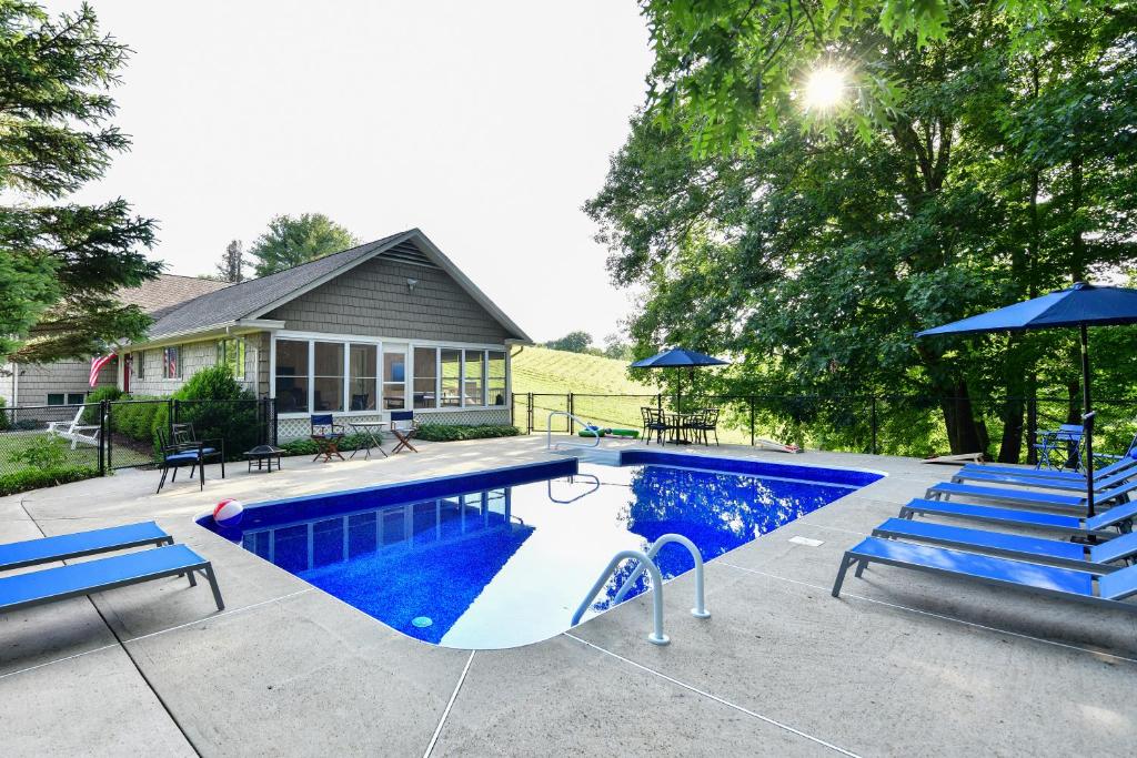 a swimming pool with a slide and blue benches at Old Litchfield, Washington CT in Washington