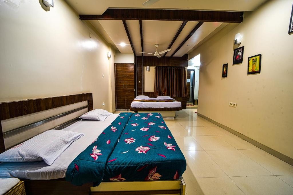 um quarto com duas camas num quarto em Hotel Sony Palace, Kolhapur em Kolhapur