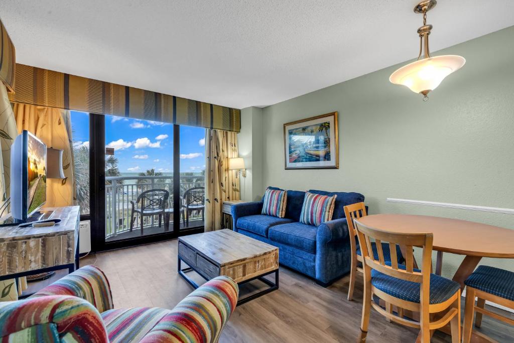 uma sala de estar com um sofá e uma mesa em Bright atmosphere Oceanfront Breakers Sailfish em Myrtle Beach