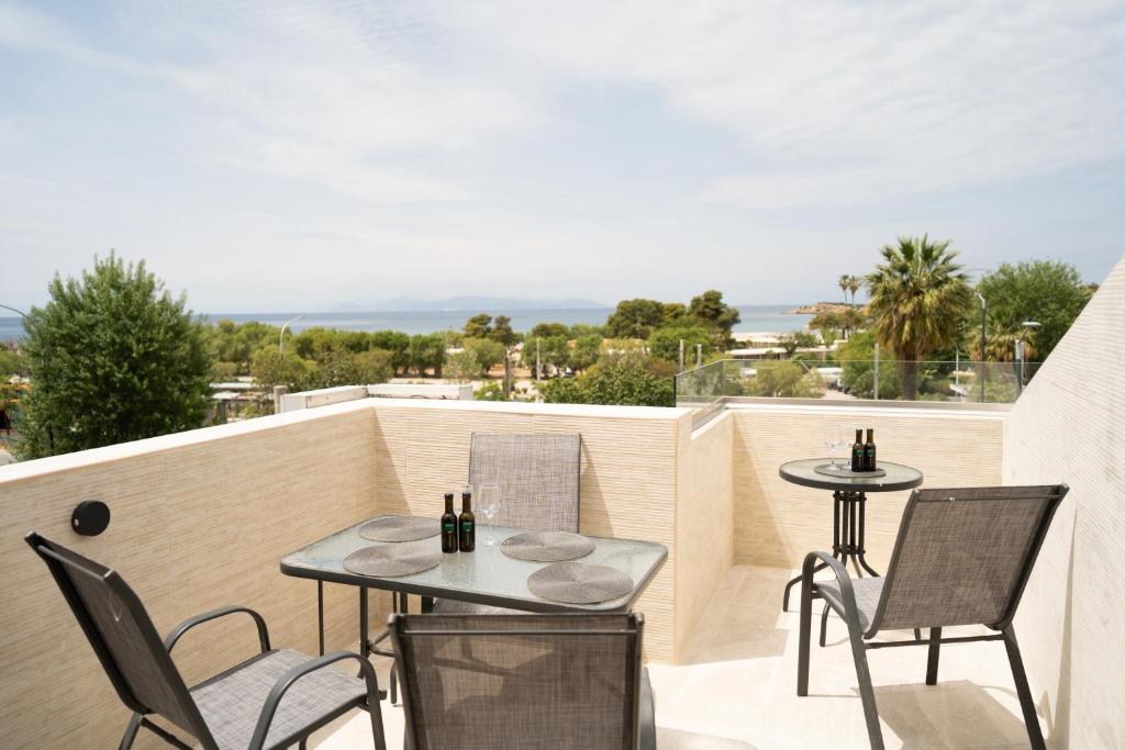 a patio with two tables and chairs on a balcony at Parthenis Riviera Hotel in Athens