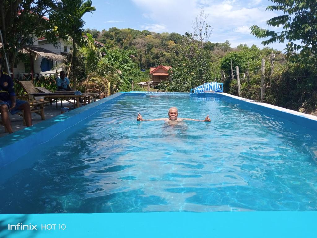 a man is swimming in a swimming pool at Lanta Dareen Garden Home in Ko Lanta