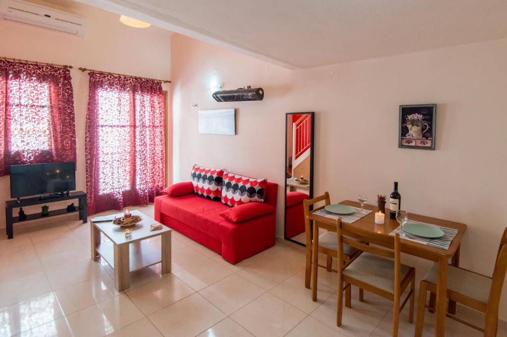un salon avec un canapé rouge et une table dans l'établissement Mat Old Town Apartments B, à Réthymnon