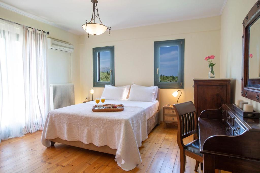 sypialnia z łóżkiem ze stołem i oknami w obiekcie Serene villa Meganisi - Seaview & Exclusive Pool w mieście Meganisi