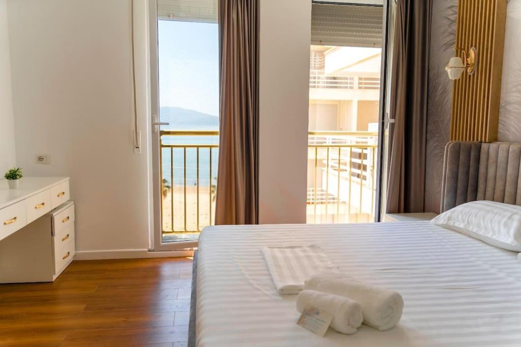 a bedroom with a bed with a view of a balcony at Paradise Dream Apartment in Vlora in Vlorë