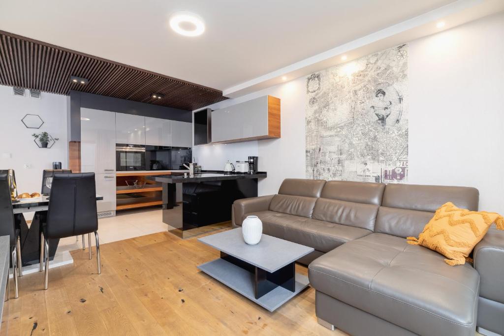 a living room with a couch and a kitchen at Diamond Apartment by Renters Prestige in Kraków