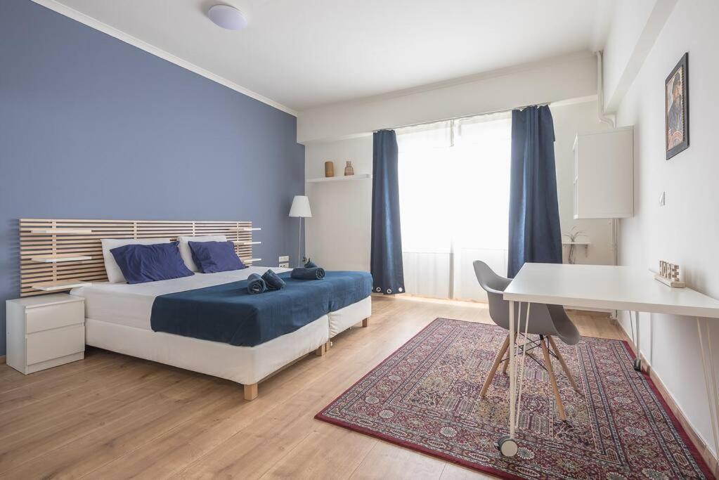sypialnia z łóżkiem, stołem i biurkiem w obiekcie Veni Central View 2Bdr Apt w Atenach