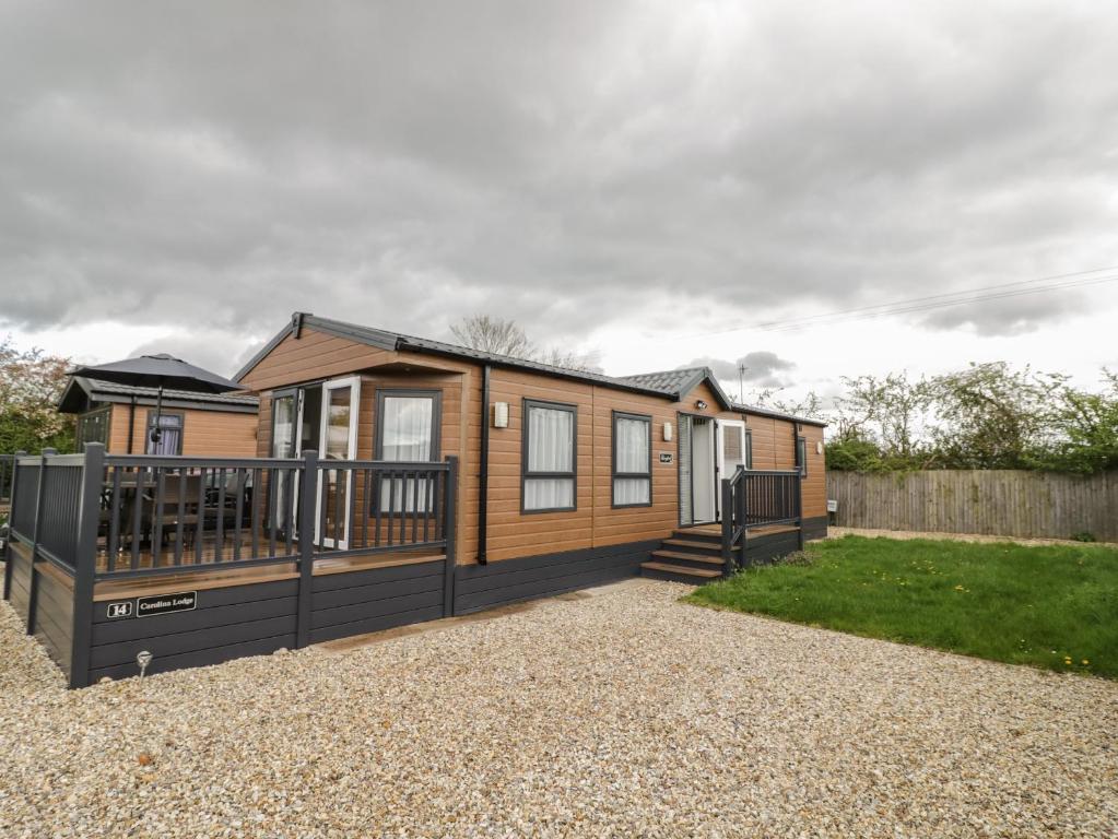 a log cabin with a deck and a fence at Carolina Lodge in Evesham