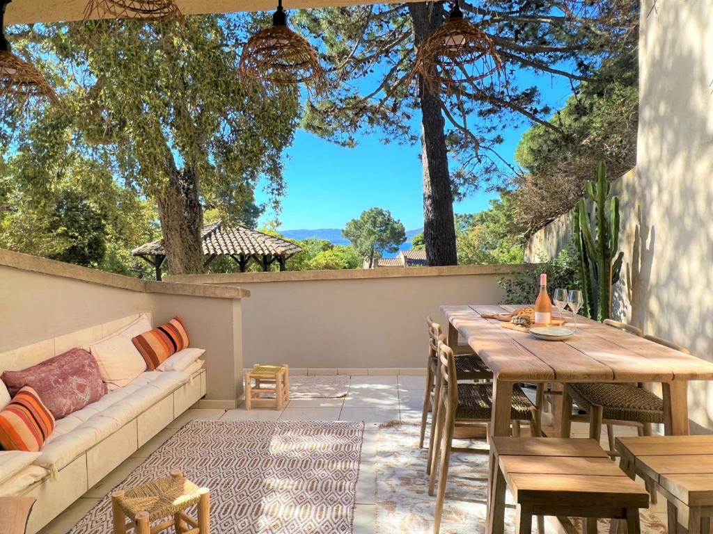 un patio con sofá, mesa y sillas en Casetta Cala Rossa, en Lecci