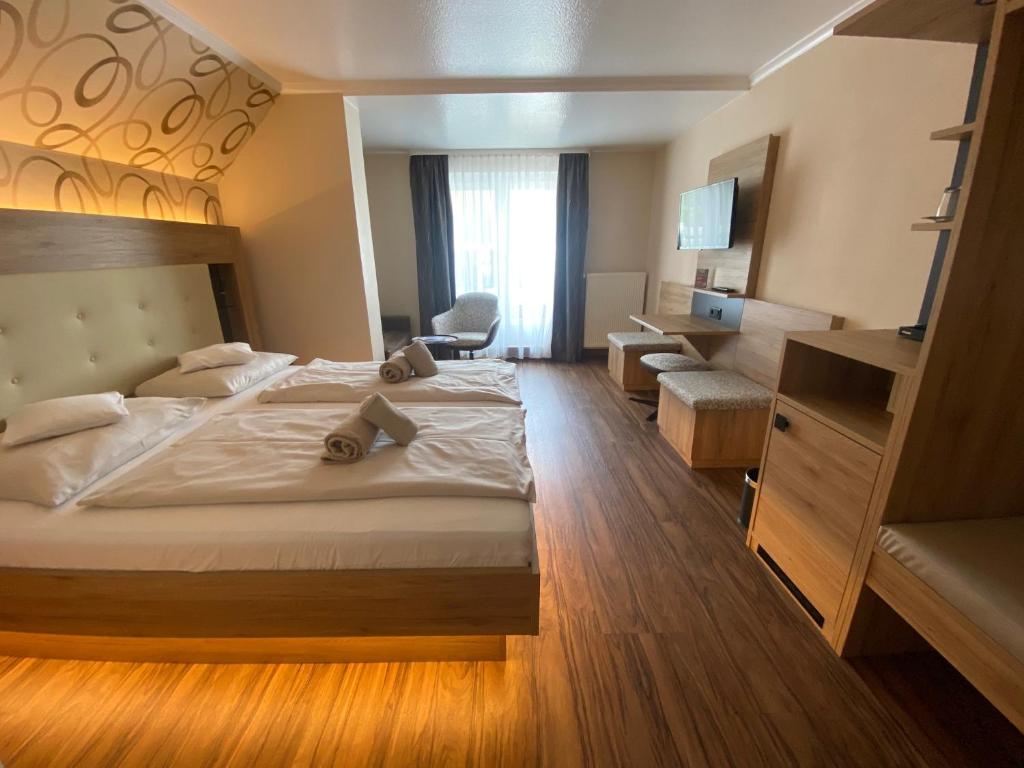 a hotel room with a large bed and a chair at Apart Hotel Haveltreff in Caputh