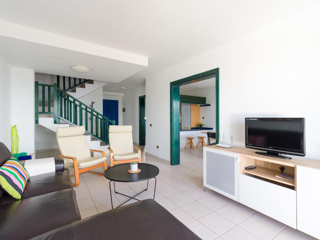 a living room with a couch and a flat screen tv at Las Moreras Playa Blanca in Playa Blanca