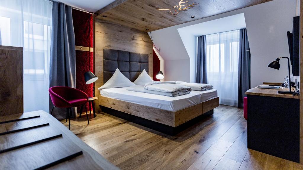 een slaapkamer met een bed en een bureau in een kamer bij Hotel Hirsch in Neu Ulm