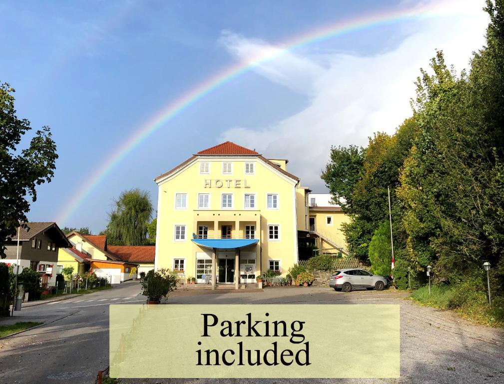 un arco iris sobre un edificio con aparcamiento incluido en Austria Classic Hotel Heiligkreuz, en Hall in Tirol