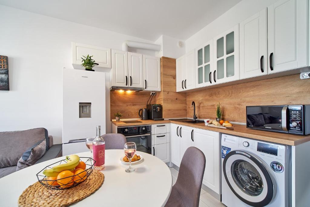 a kitchen with a table with a bowl of fruit on it at Cozy Apartment with Balcony on the Black Sea- part of the family 'Vicki Apart in Varna City