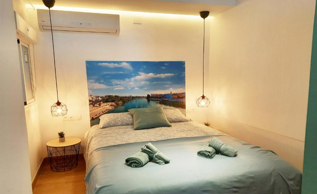een slaapkamer met een bed met een schilderij aan de muur bij Sunny Terrace - Lovely Center Apartments Alameda in Sevilla
