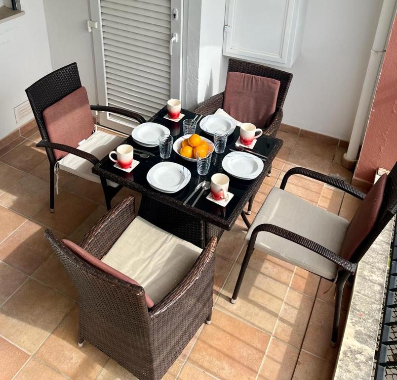 una mesa con platos y tazones de comida. en Casa Ana at Opomar by Cara Rentals, en Tavira