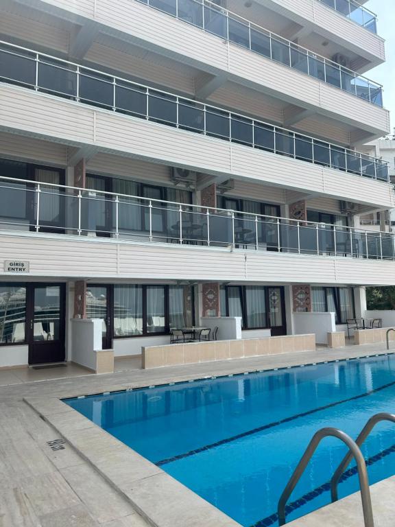 a swimming pool in front of a building at Hotel Stella in Kusadası