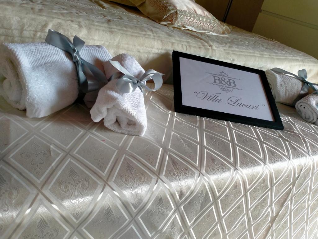 ein Bett mit Handtüchern und ein Schild drauf in der Unterkunft B&B Villa Lucari in Comiso