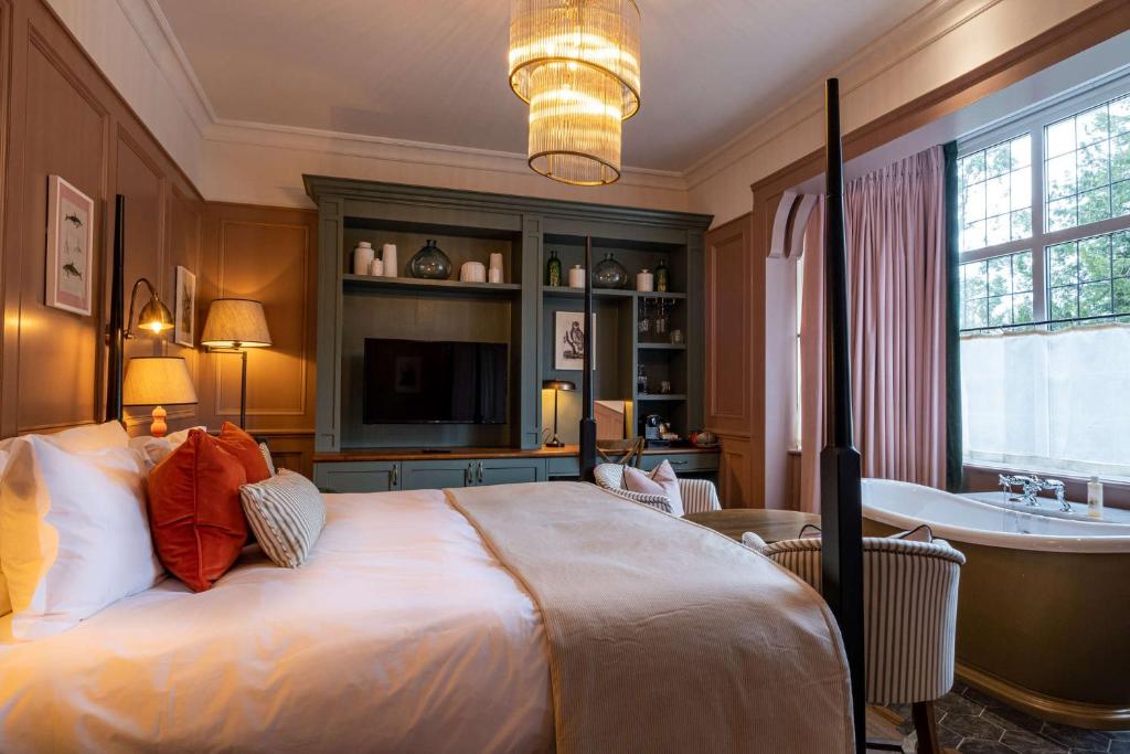a bedroom with a bed and a tub and a sink at The Canford in Poole