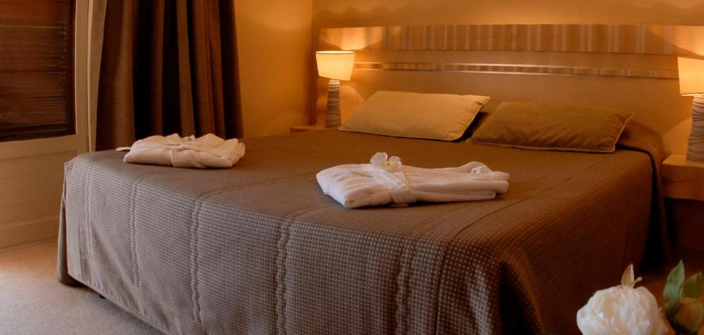 two towels on a bed in a hotel room at Hôtel Capo Rosso in Piana