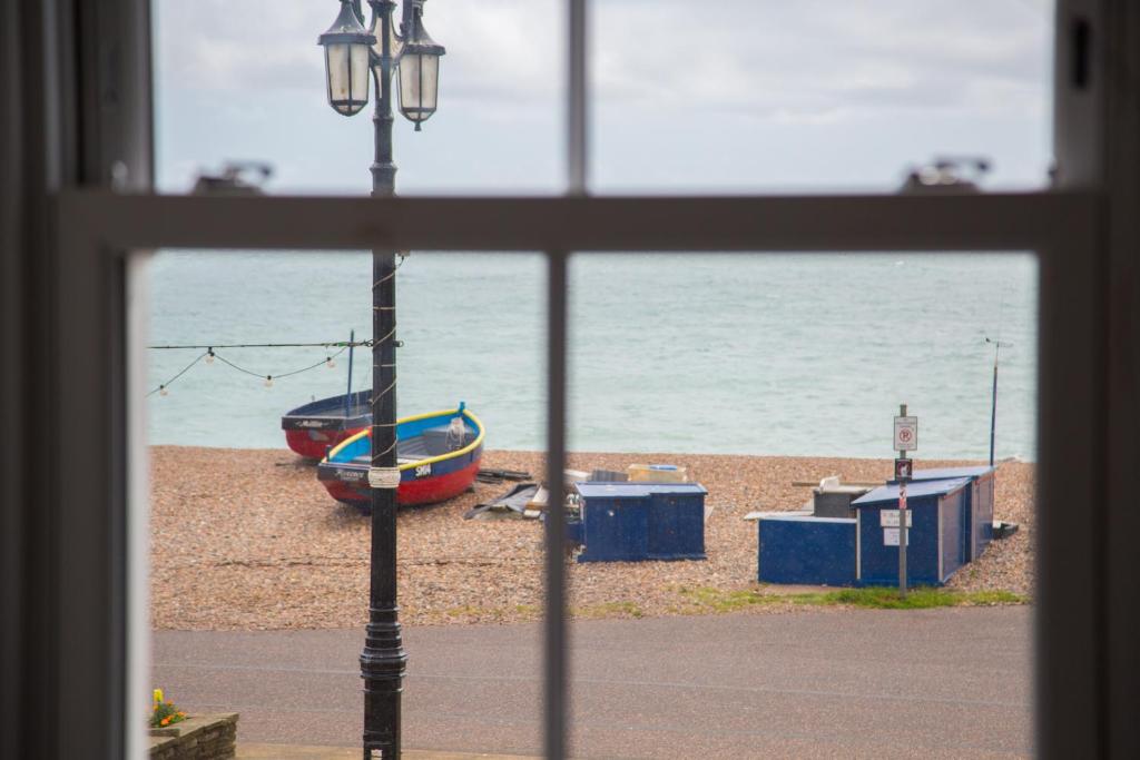 una ventana con vistas a una playa con un barco en Lovely 2- Bedroom Apartment with Stunning Sea Views, en Worthing