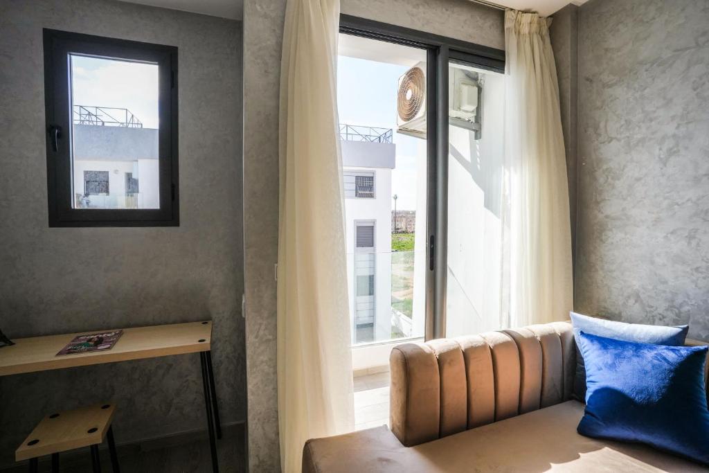 salon z kanapą i oknem w obiekcie Charming apartment in Ain Sebaa w mieście Casablanca