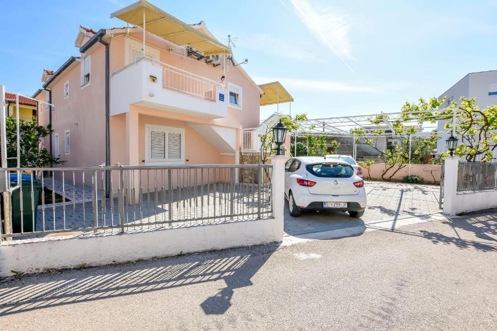 a small car parked in front of a house at Apartments Zdravko in Rogoznica