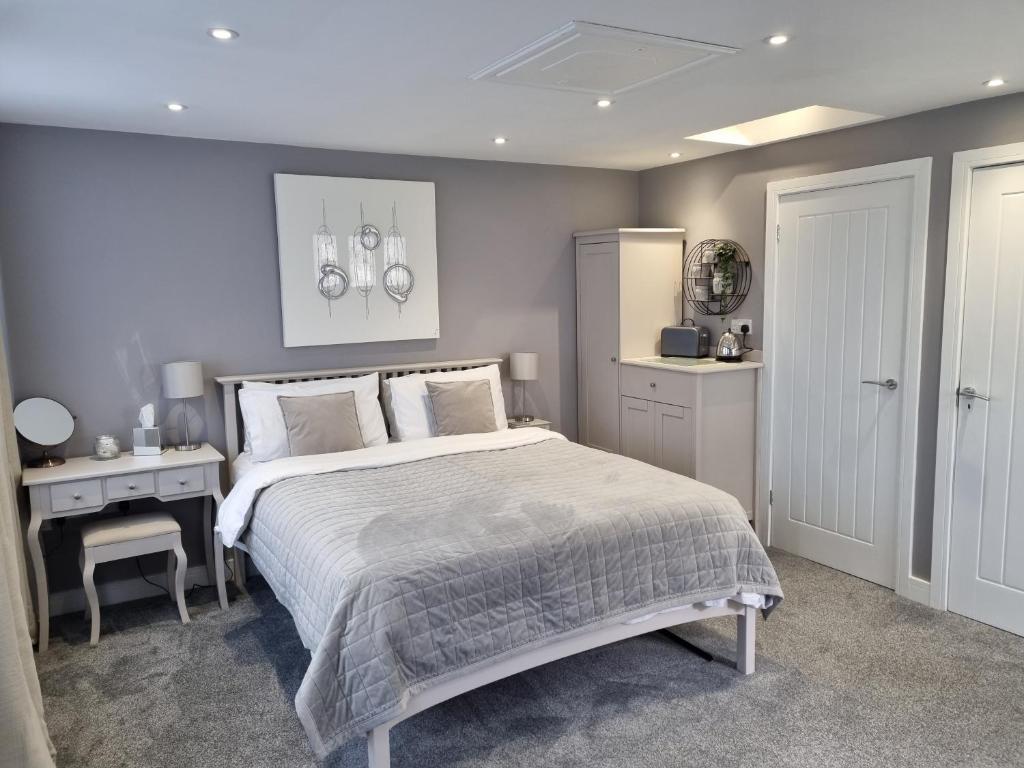 a bedroom with a large bed and a desk at The Boathouse in Lee-on-the-Solent