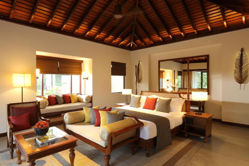 a bedroom with a bed and a living room with a couch at Anantara Peace Haven Tangalle Resort in Tangalle