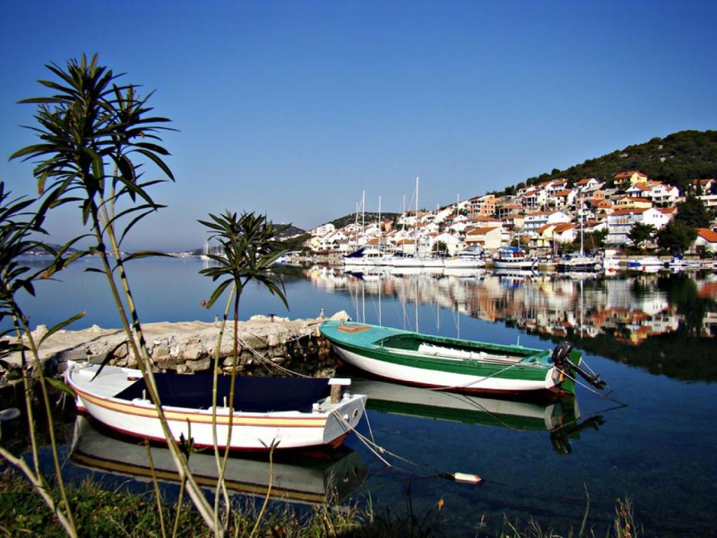 two boats are docked in the water near a harbor at Mobile Home Aloha in Tisno