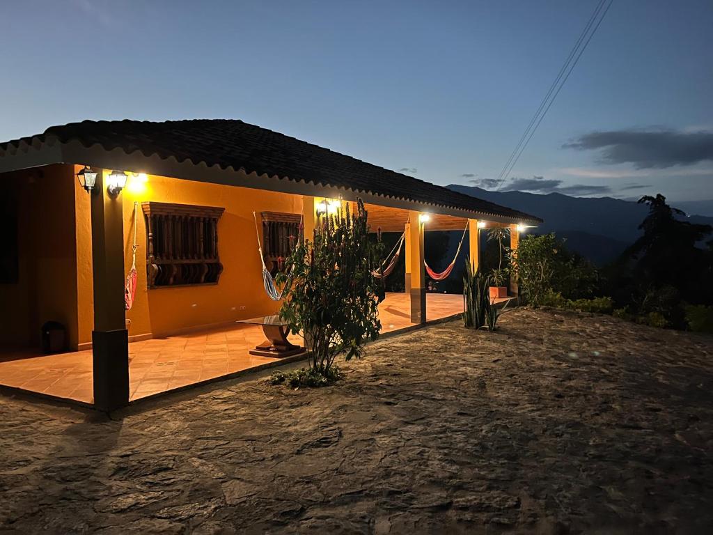 a small house with a deck at night at Casa Campestre Sueño Verde in Garagoa