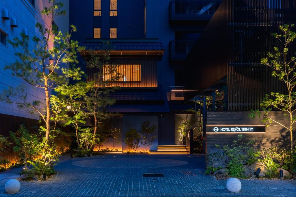 a building with a courtyard at night at Hotel Resol Trinity Osaka in Osaka