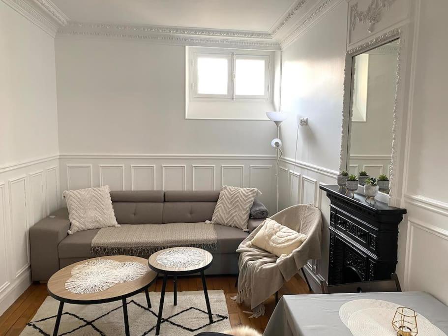 a living room with a couch and a table at Charmant appartement cosy 2 pièces Paris 15e in Paris
