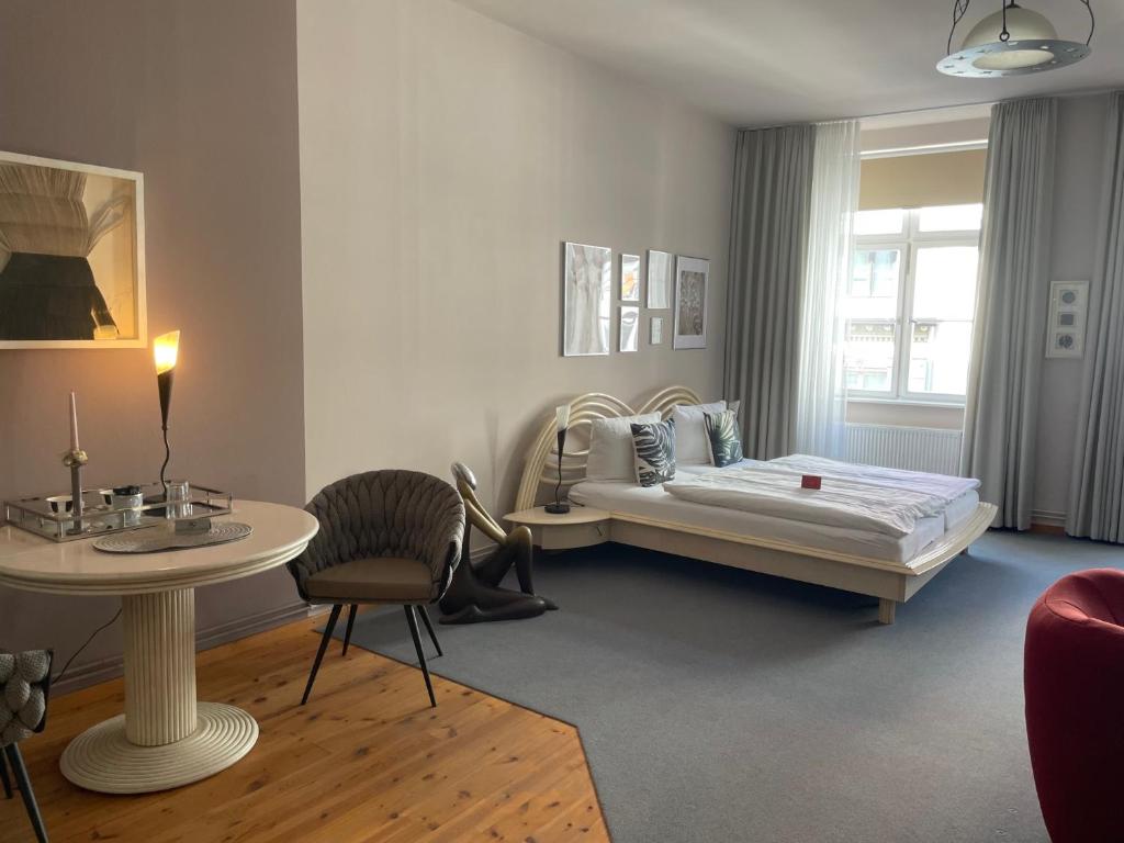 um quarto com uma cama, uma mesa e uma cadeira em Haus Wullfcrona em Stralsund