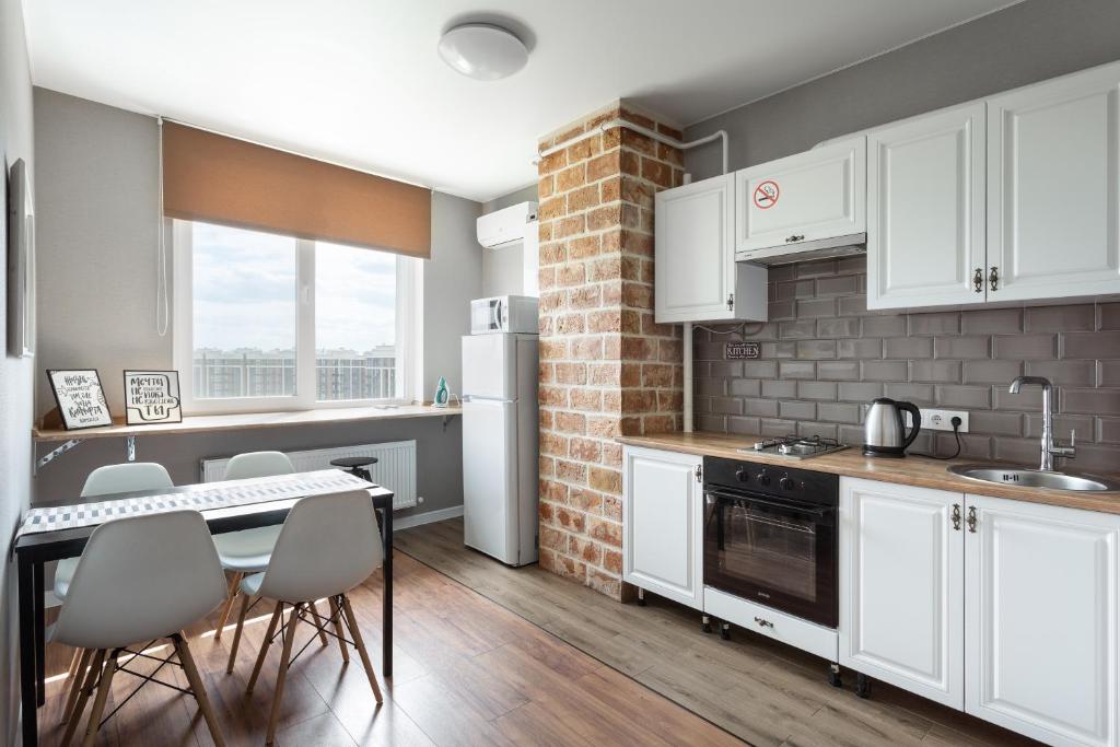 uma cozinha com armários brancos e uma parede de tijolos em 0157 Сучасні нові апартаменти ЖК Щасливий em Kiev