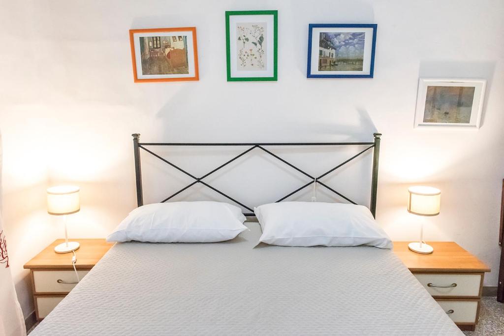 a bed with two white pillows and two lamps at N050 - Numana, trilocale in centro con portico e posto auto in Numana