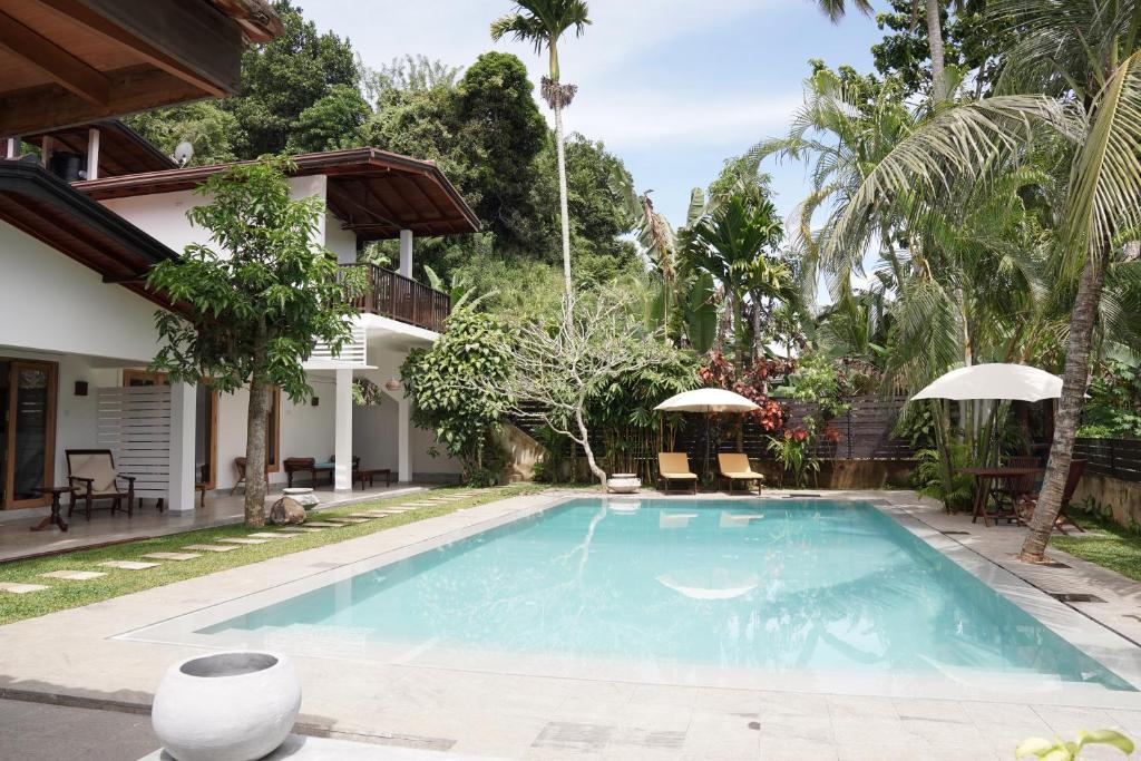 una piscina en el patio trasero de una casa en The Secret Guesthouse en Mirissa