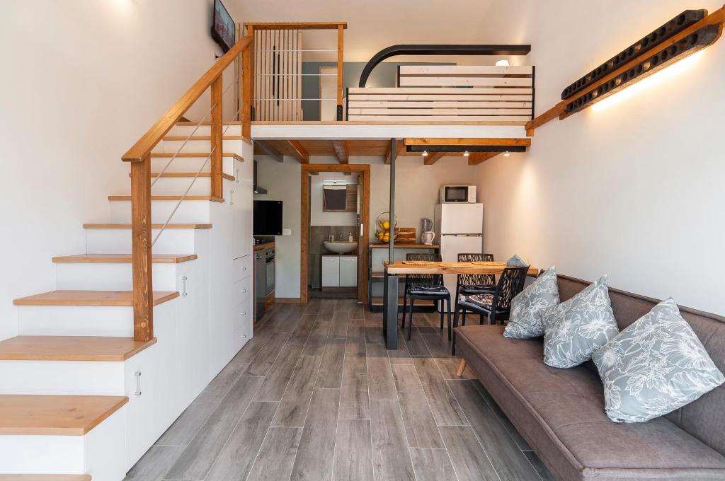 ein Wohnzimmer mit einem Sofa und einer Treppe sowie eine Küche in der Unterkunft Circeo Holiday Houses in San Felice Circeo