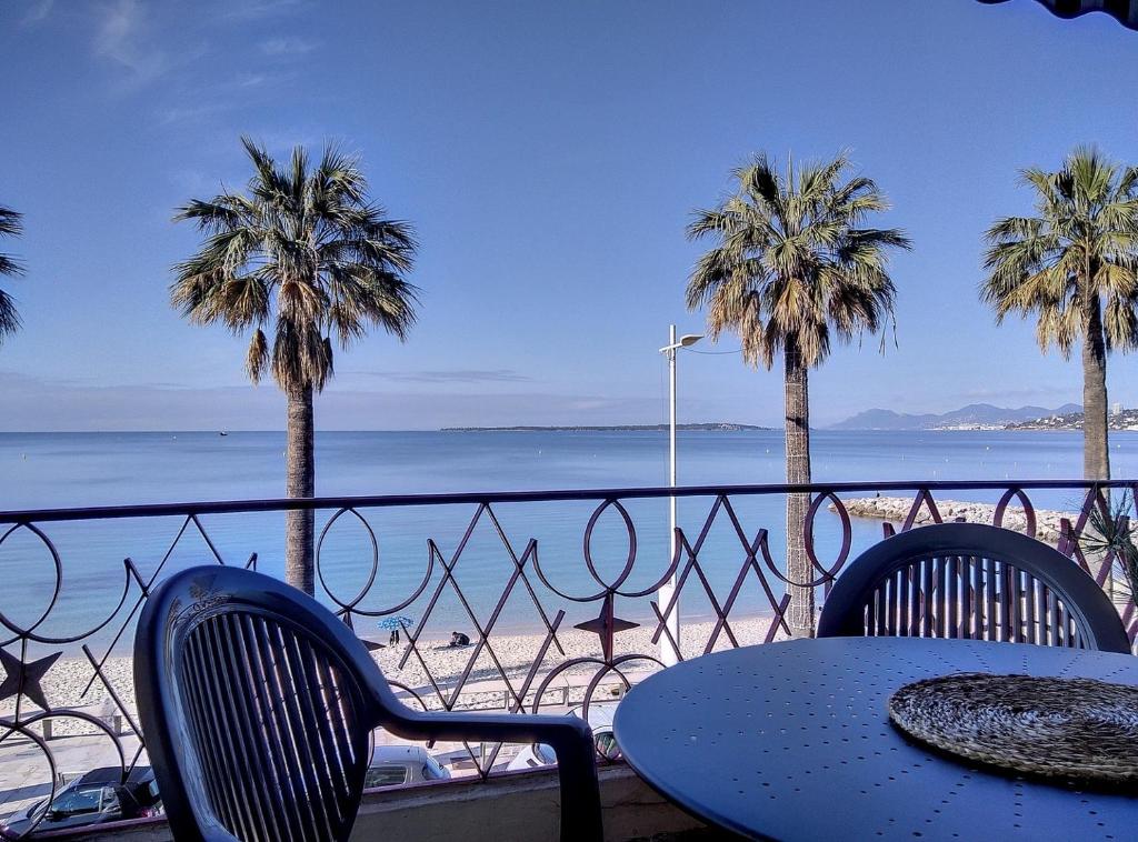 - une table et des chaises avec vue sur la plage dans l'établissement Constellation, à Juan-les-Pins