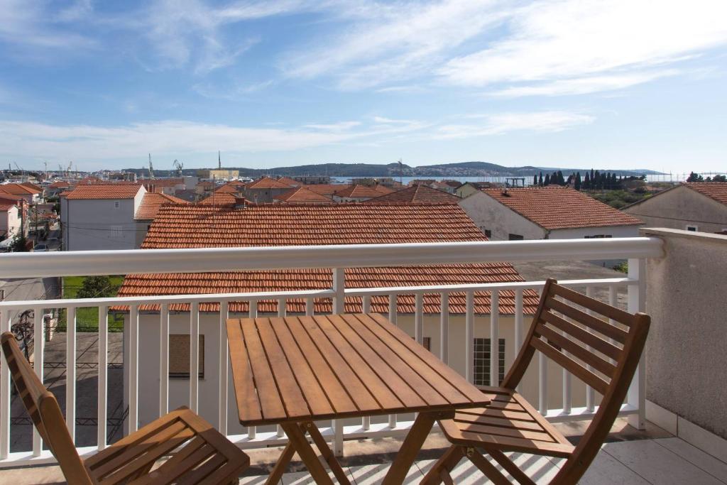 - Balcón con mesa de madera y 2 sillas en Apartments Betanija, en Trogir