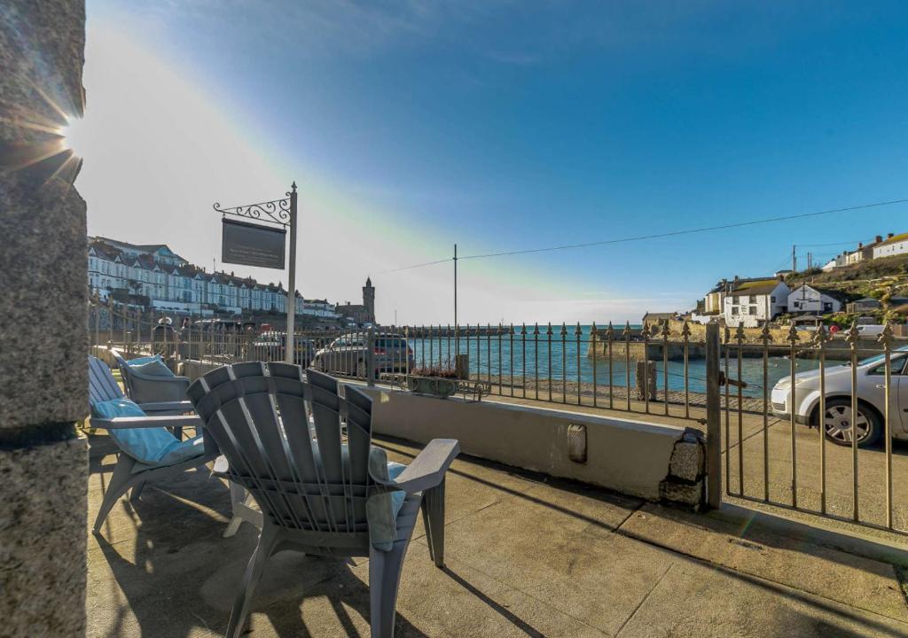a chair sitting on a balcony overlooking the ocean at Seaview Moorings in Porthleven