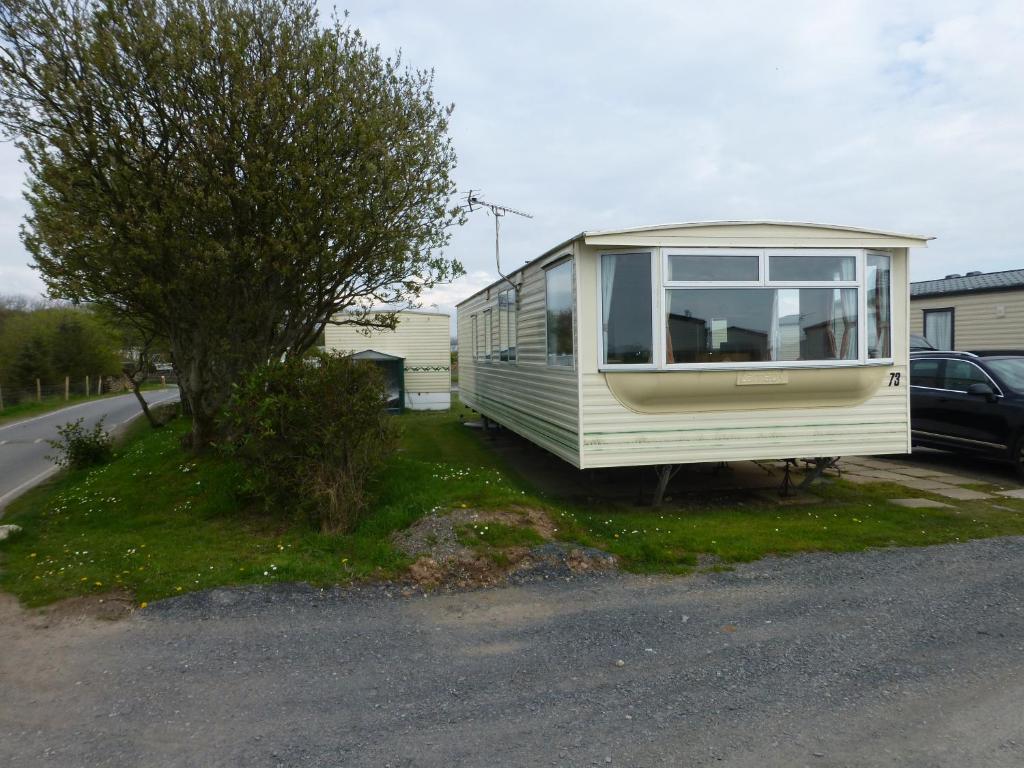 a tiny house sitting on the side of a road at 73 Port Haverigg in Millom
