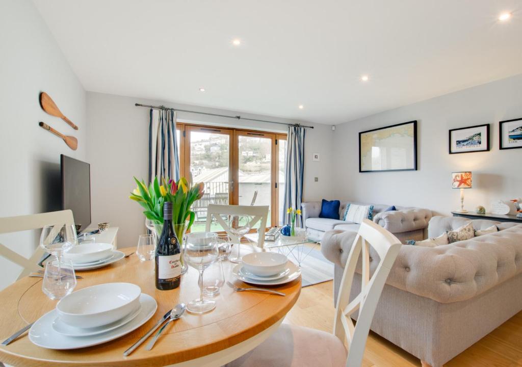 a dining room and living room with a table and chairs at Number Six The Creekside in Looe