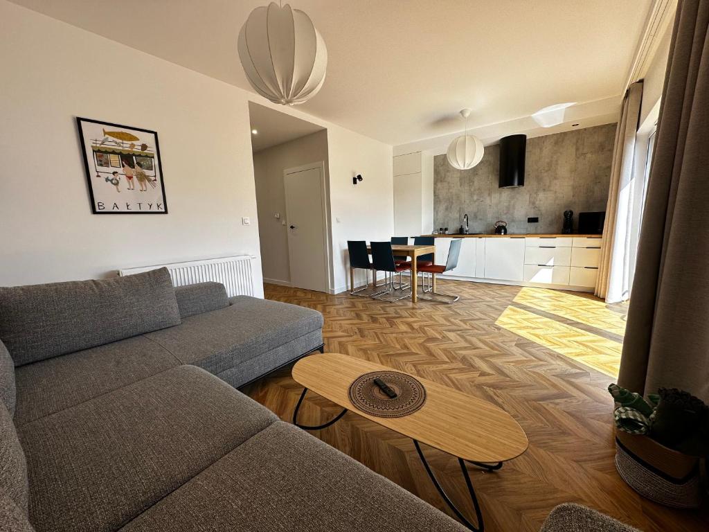 uma sala de estar com um sofá e uma mesa em Apartament Marina em Pierwoszyno