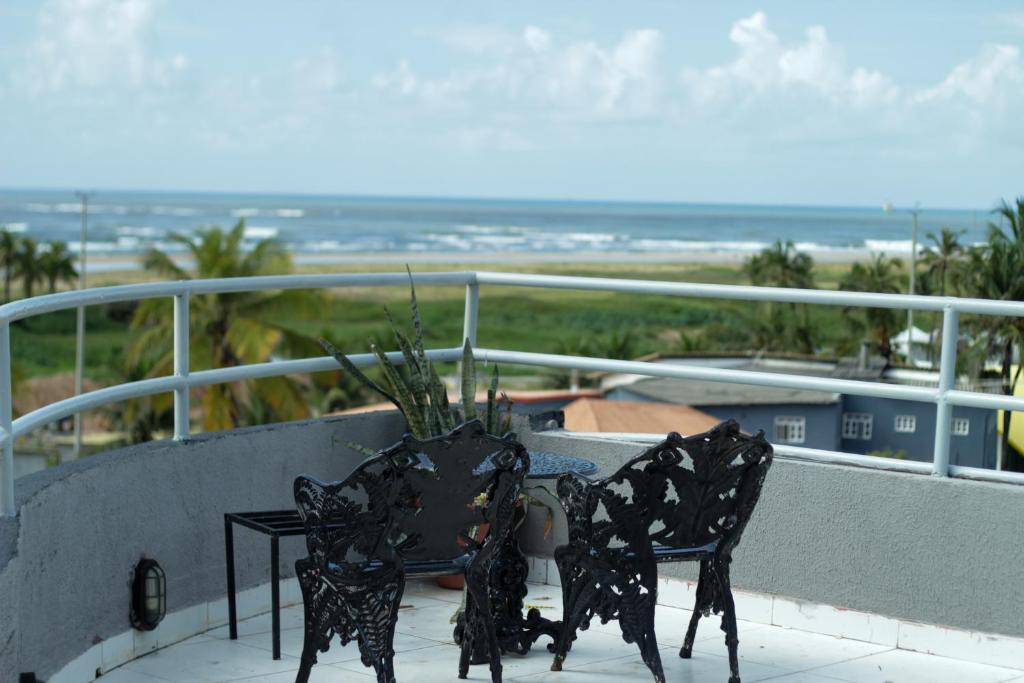 a balcony with two chairs and a table with a plant at HOTEL Al ATLANTICO in Aracaju